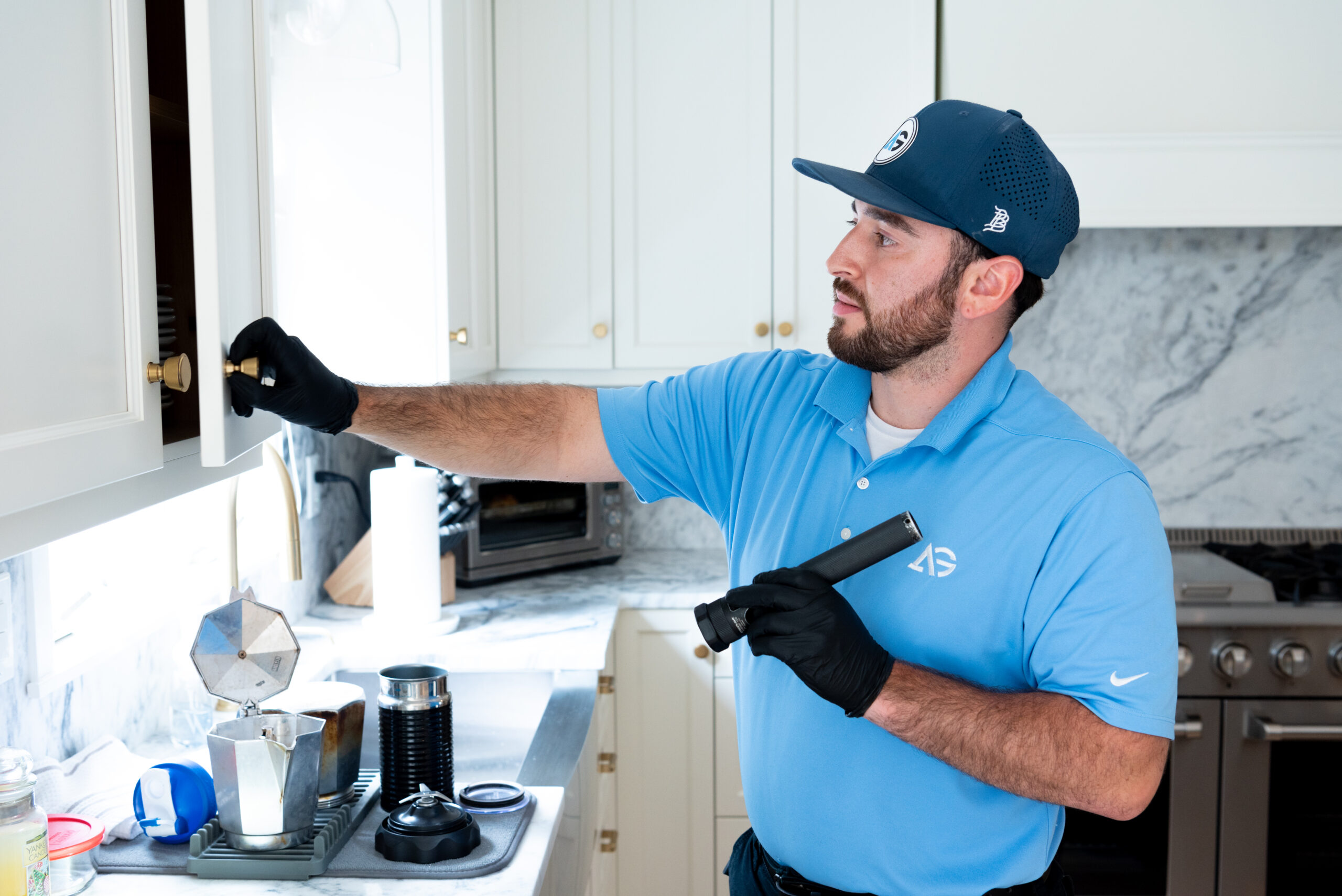 Agile Pest Control technician conducting a detailed inspection for rodent control at a home in Asbury Park, NJ.