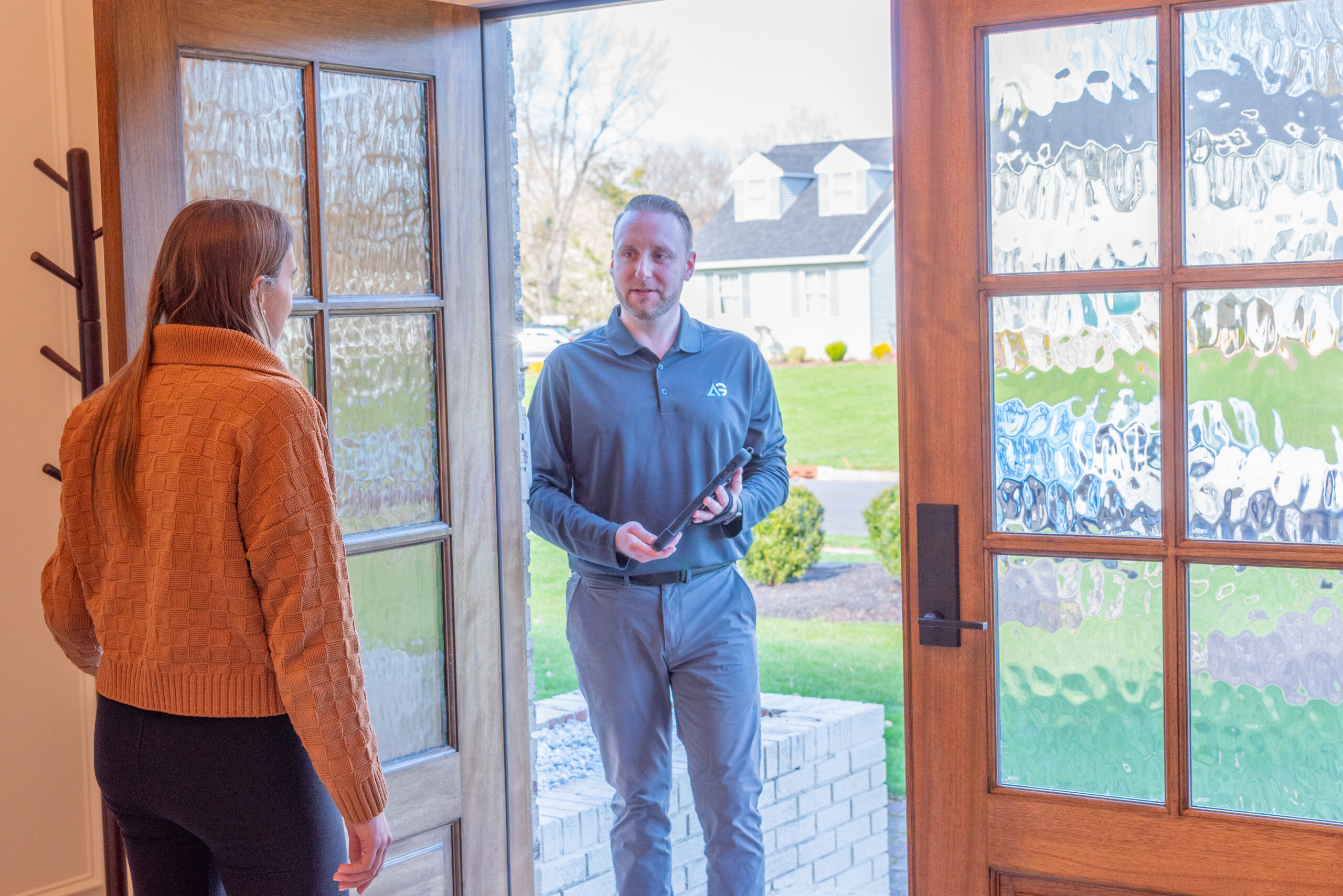 Agile Pest Control technician entering a home in Red Bank, NJ, to conduct an inspection and present a proposal.