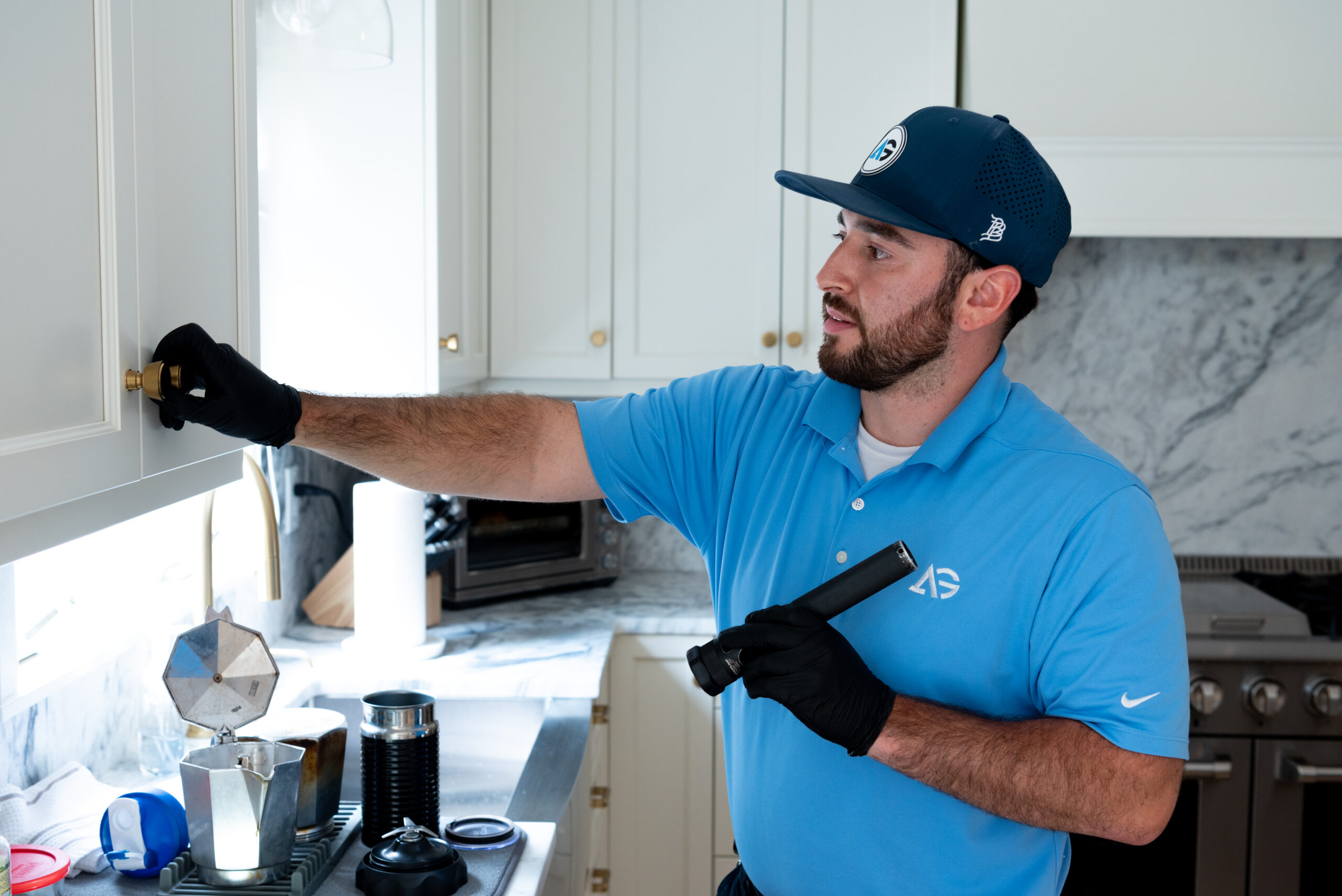 gile Pest Control technician conducting a thorough interior inspection for rodent control inside a Freehold, NJ home, carefully examining potential entry points and signs of infestation.