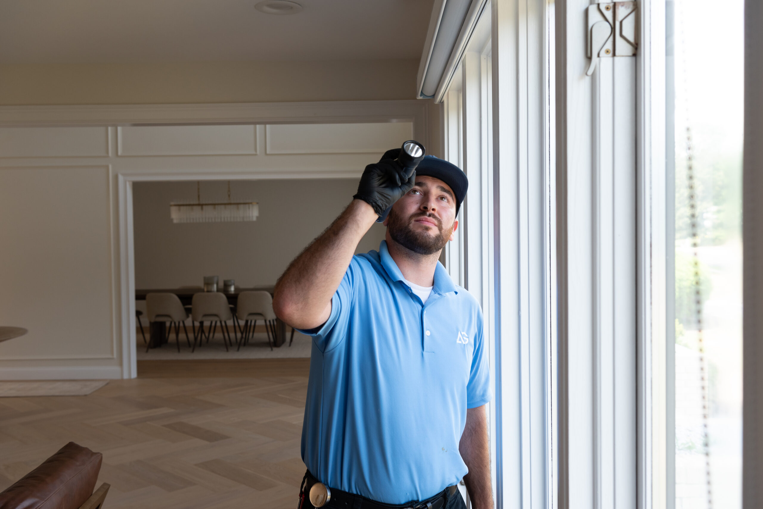 Agile Pest Control technician conducting a detailed interior bed bug inspection in a home in Asbury Park, NJ, carefully checking furniture and potential hiding spots for signs of infestation.