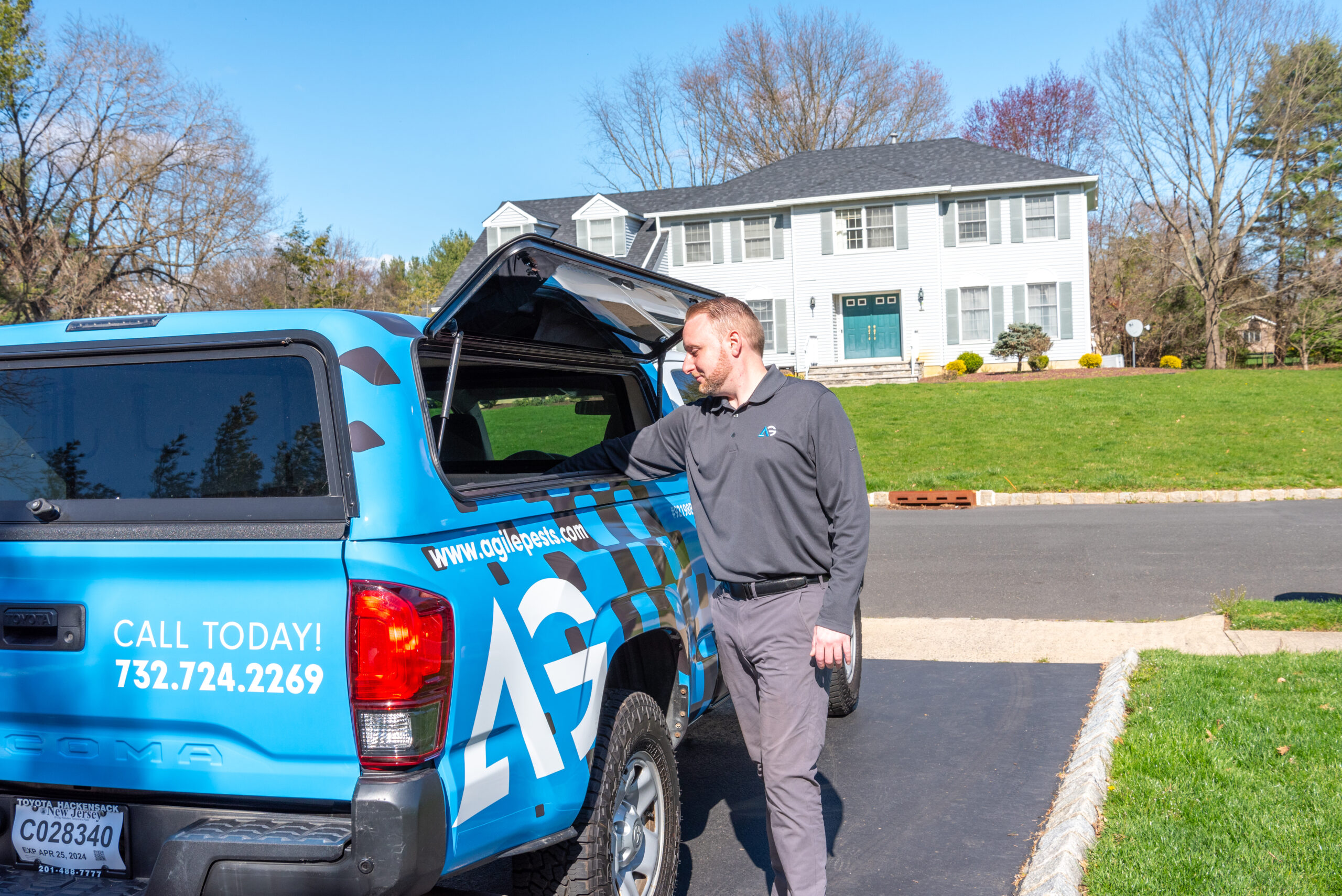 An Agile Pest Control technician arrives at a home to provide cockroach control in Holmdel, NJ, equipped with the necessary tools for inspection and treatment.