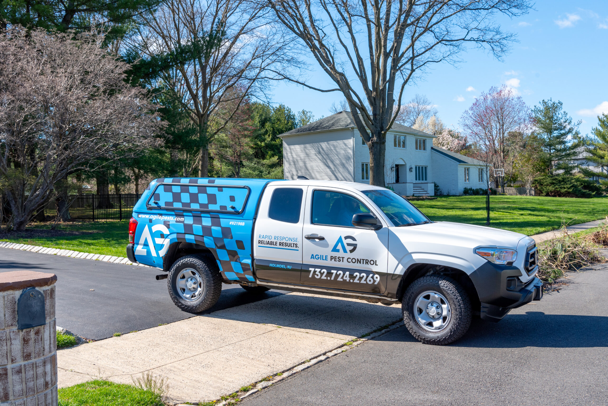 Agile Pest Control truck parked in the driveway of a home in Wall, NJ, prepared for a scheduled bed bug control service, highlighting the company's commitment to local pest management solutions.