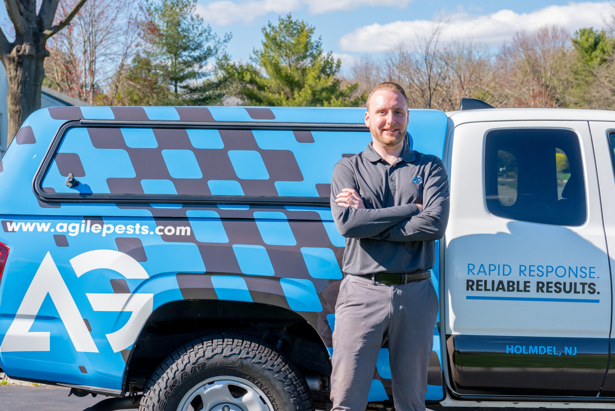 Agile Pest Control technician standing in front of his service truck in Hazlet, NJ, preparing for a rodent control service.