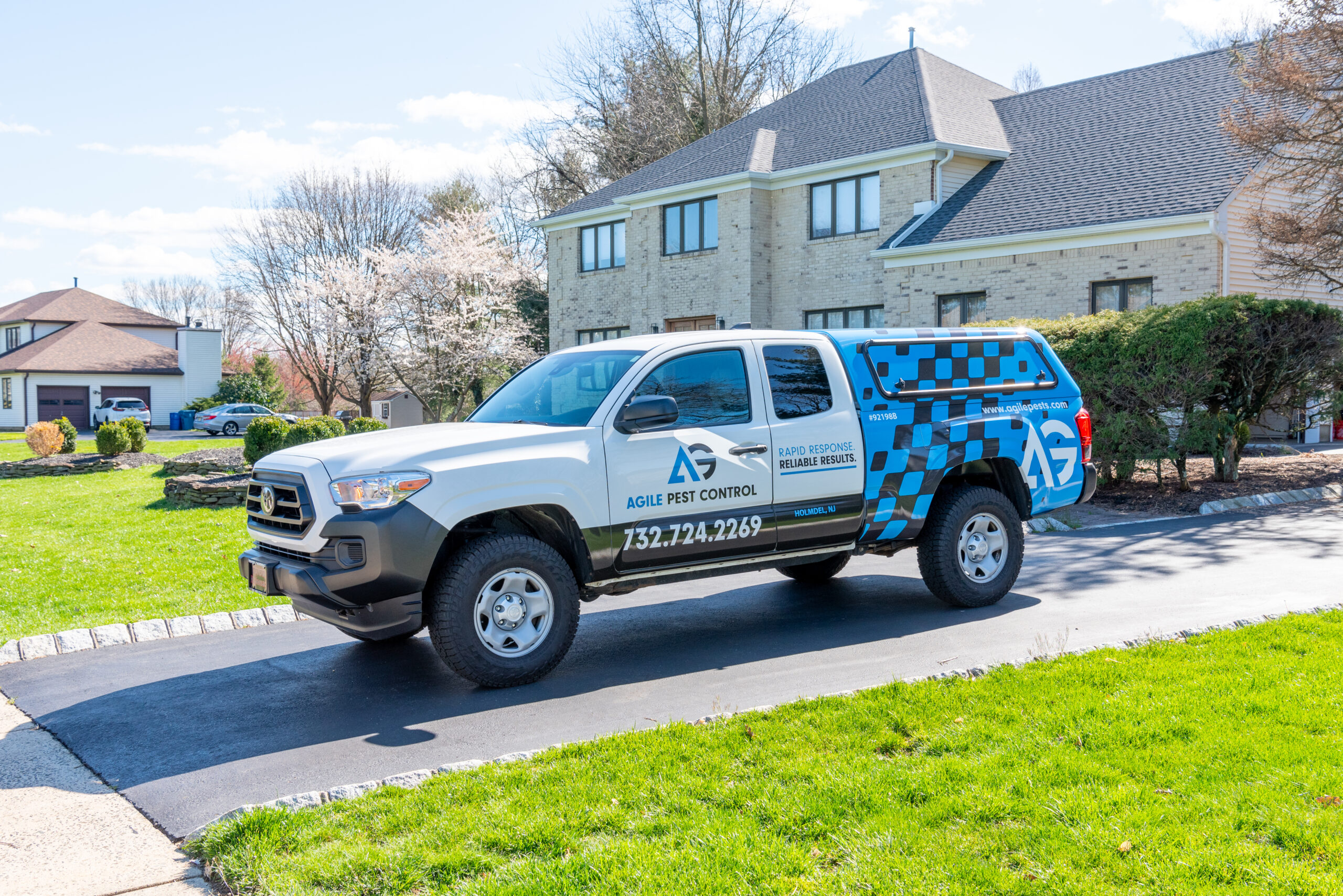 Agile Pest Control truck parked in the driveway of a home in Colts Neck, NJ, preparing to perform a thorough bed bug control service.