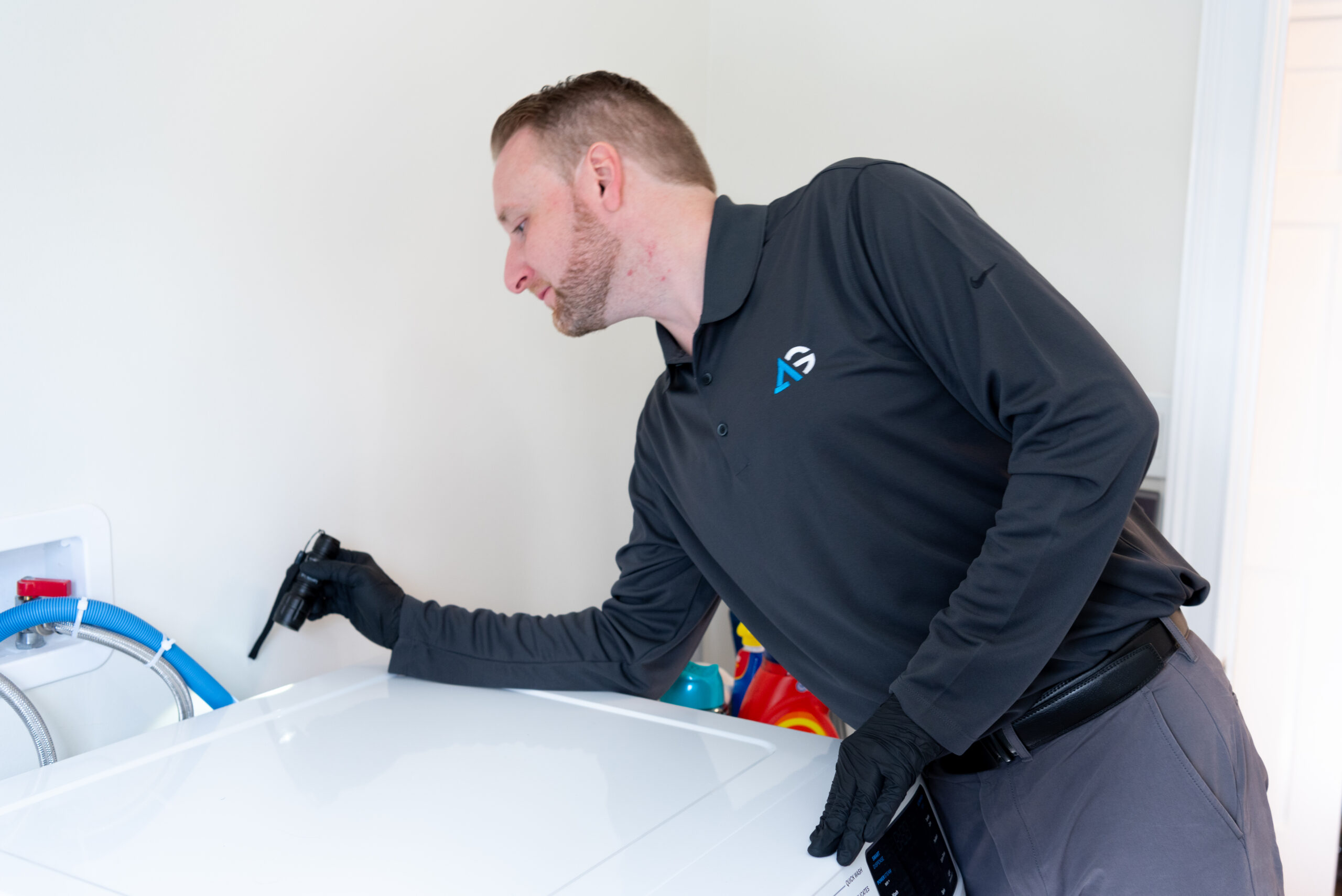 Agile Pest Control technician in Howell, NJ, preparing equipment for a thorough bed bug inspection, standing near a residential home, ready to assess and treat potential infestation areas.