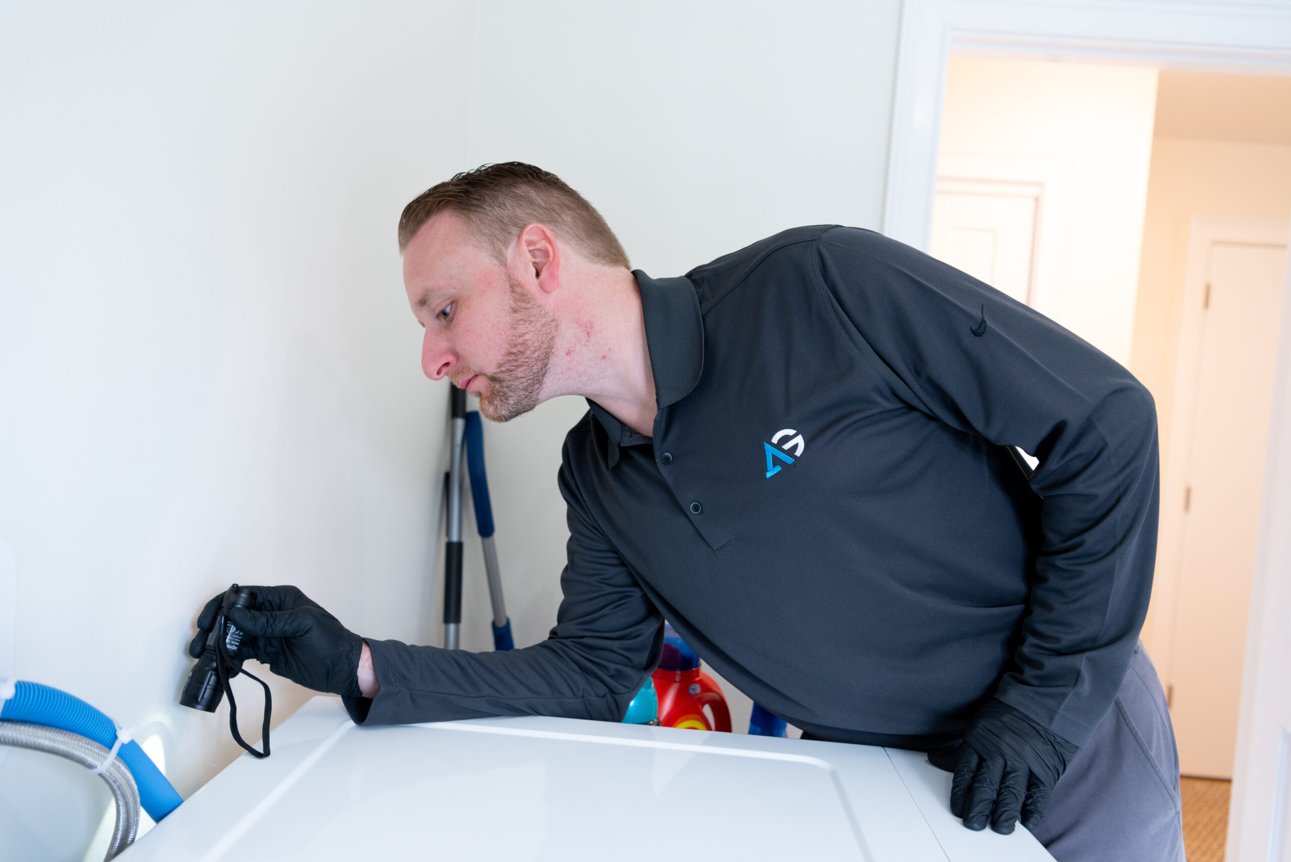 Agile Pest Control technician conducting a thorough bed bug inspection in a home in Long Branch, NJ, carefully checking furniture and crevices for signs of infestation.