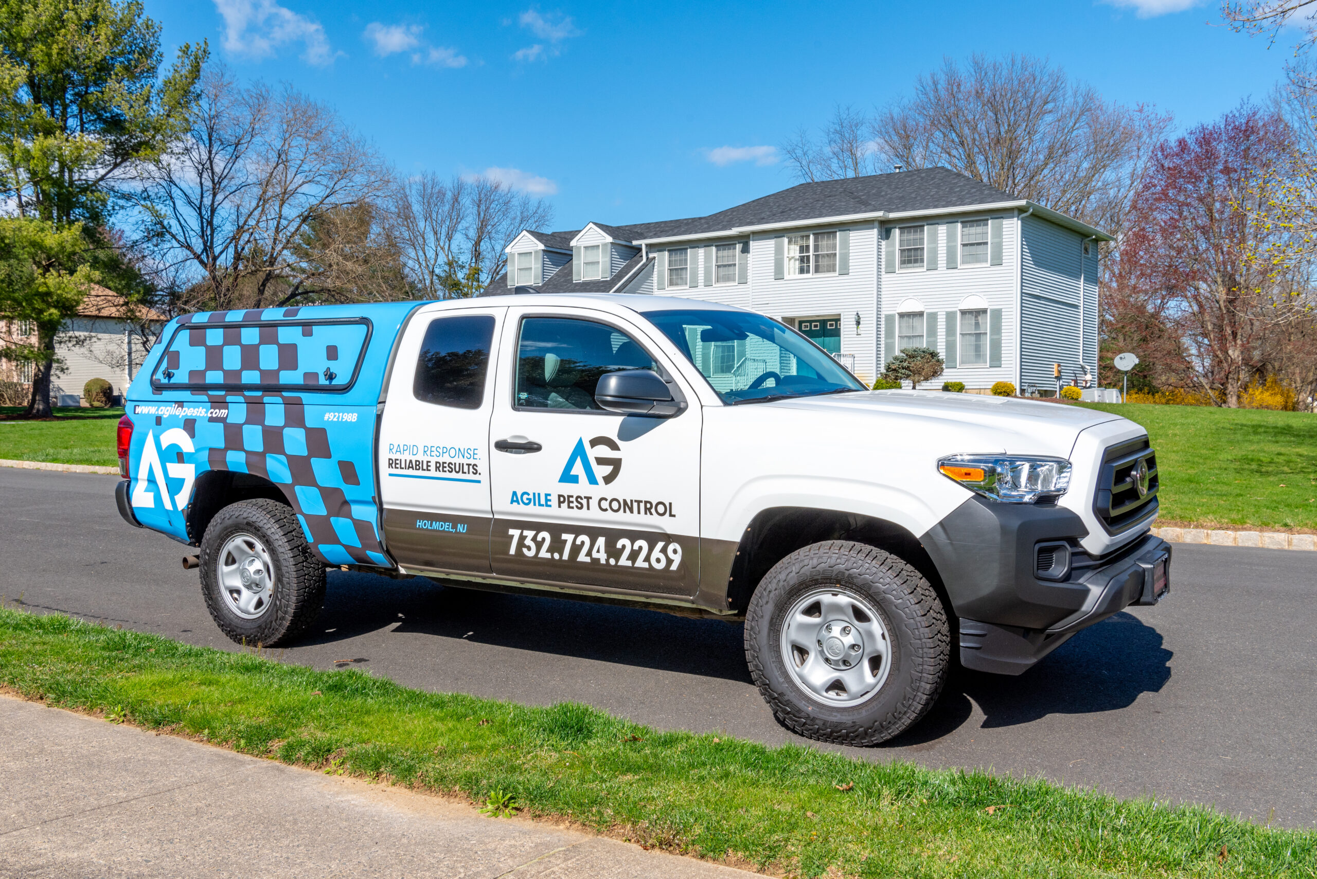 Agile Pest Control technician standing in the driveway of a home in Hazlet, NJ, preparing for a bed bug inspection. The technician, wearing a professional uniform, is equipped with inspection tools, ready to deliver expert bed bug detection and control services to ensure a pest-free home for the local homeowner.