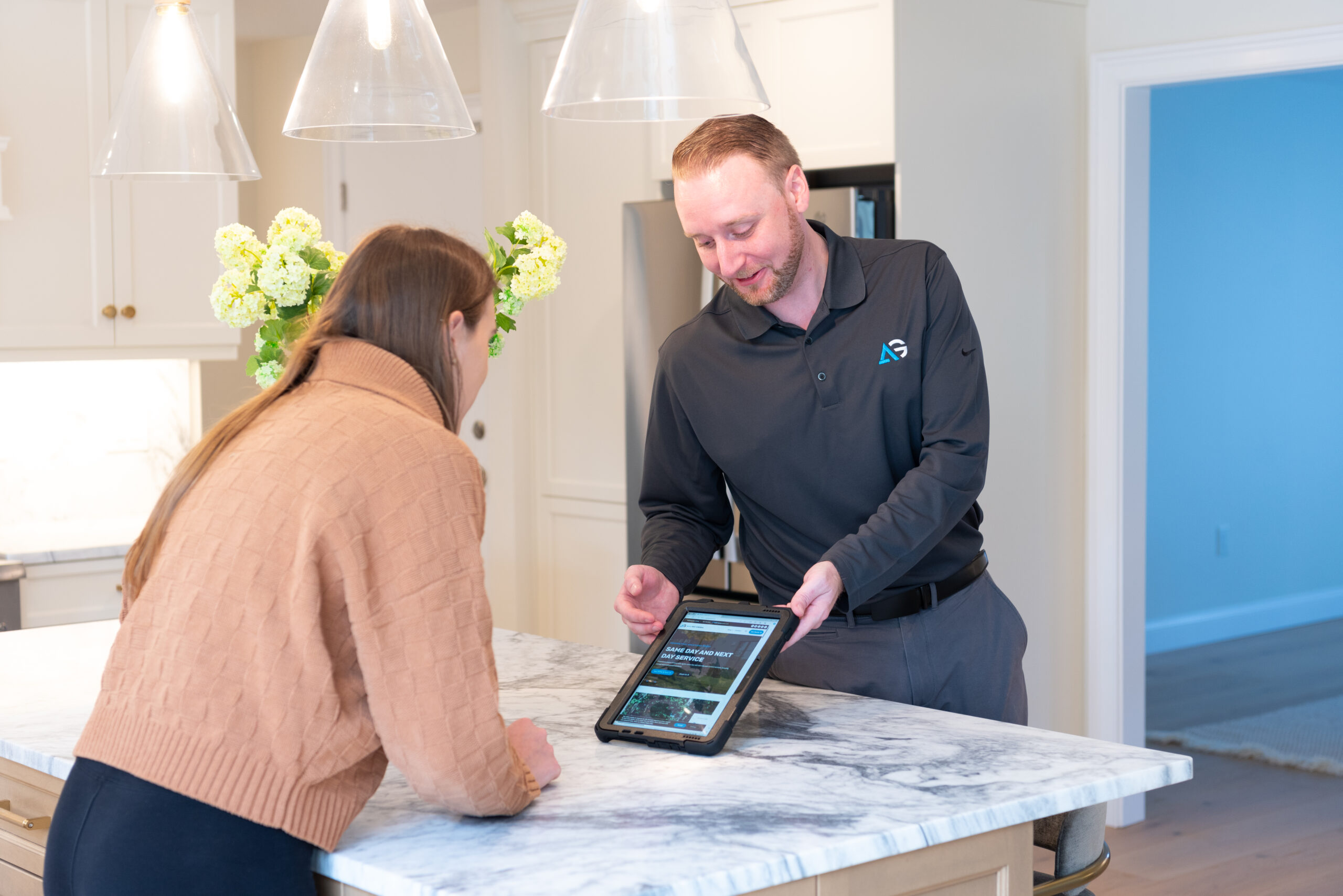 Agile Pest Control technician reviewing a detailed bed bug control proposal with a client at their home in Marlboro, NJ. The technician, in uniform, is discussing treatment options and answering questions, ensuring the client understands the comprehensive bed bug removal plan designed to effectively eliminate the infestation.