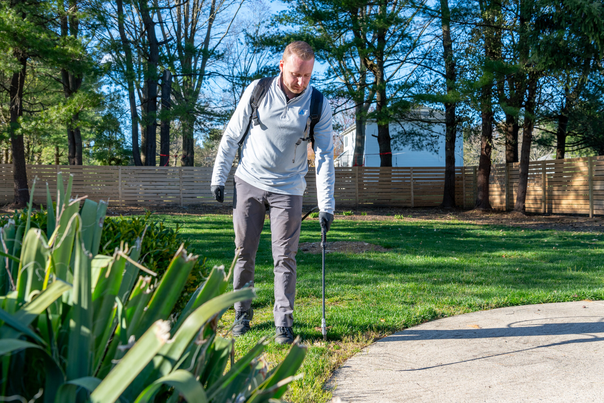Agile Pest Control technician applying ground bee treatment in a Monmouth County, NJ lawn