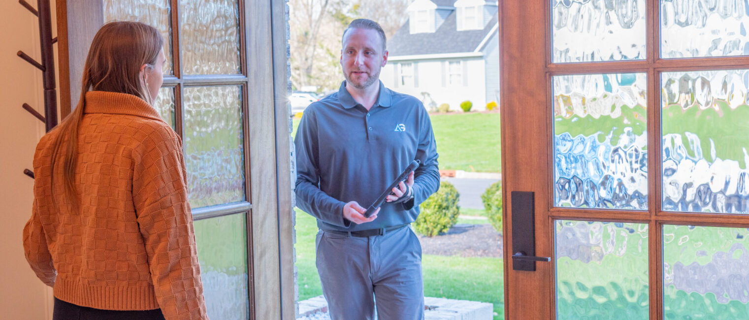 Agile Pest Control technician entering a home in Red Bank, NJ, to conduct an inspection and present a proposal.